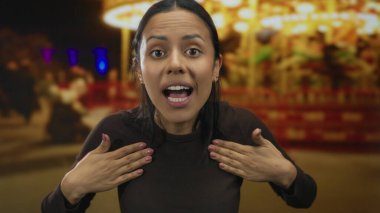 Canlı bir lunapark ortamında gece vakti canlı ışıklarıyla kameraya bağıran bir kadın sahnede heyecan ve enerji ifade ediyor..