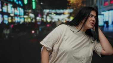 İşlek bir şehir caddesinde, geceleri kulağına gelen bir elle dikkatle dinleyen bir kadın. Işıklar ve bulanık hareket kentsel bir zemin oluşturuyor. Merakını ve uyanıklığını iletiyor..