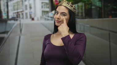 Tacını takan İspanyol kadın, şehir dışındaki bir sokakta kendine güvenerek, şehirde güç ve zarafeti somutlaştırıyor..