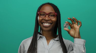 Elinde ethereum para tutan kadın yeşil arka planda gülümsüyor, kripto para birimi coşkusu sergiliyor ve pozitif ifade engelleme teknolojisini destekliyor..