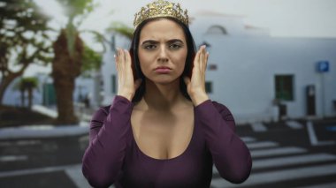 Taçlı genç İspanyol kadın açık bir sokakta çeşitli duygusal ifadeler sergiliyor..