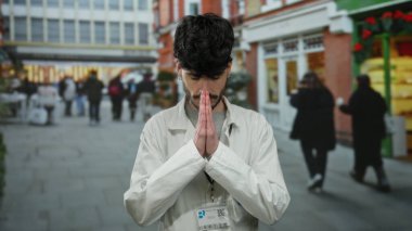 Beyaz labaratuar bornozu içindeki genç adam şehir sokaklarında geziyor..