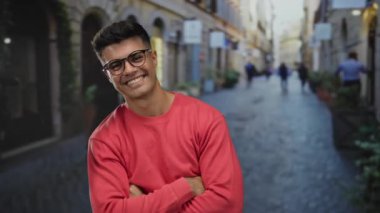 Şehrin caddesinde kendine güvenen genç bir adam gözlük takıyor ve kırmızı bir süveter giyiyor. Geçmişi bulanık, büyüleyici ve arkadaş canlısı..