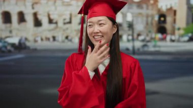 Mezuniyet kıyafetli bir kadın, Roma kolezyumunun önünde gülümsüyor kültürel başarıları sembolize ediyor..