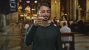 Genç adam sabah ayini sırasında dekoratif kilise binasında kamerayı işaret ediyor. Umut ışığı..