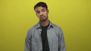 İspanyol adam, izole edilmiş sarı arka planda el çırpıyor. Günlük kıyafetler giyiyor ve anlamlı bir görünüm sergiliyor..