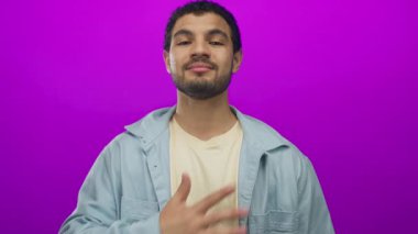 Erkek debriyaj stüdyosu canlı mor ekran karşısında doğrudan bakışlar, açık kot gömlek giyme; minnettarlık.