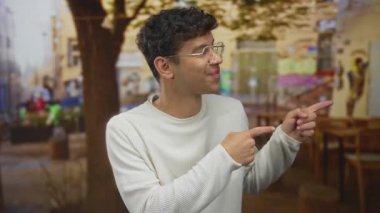 Ahşap masalar ve bulanık lokantalarla teras inşaatında iki işaret parmağı da sağdaki adamı işaret ediyor. Sürpriz tepki..