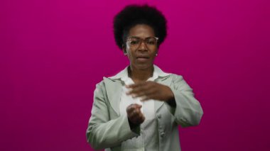 Gözlüklü, yeşil ceketli, izole edilmiş pembe arka planda mola veren bir kadın mola, duraklama ya da dinlenme anlamına gelir..