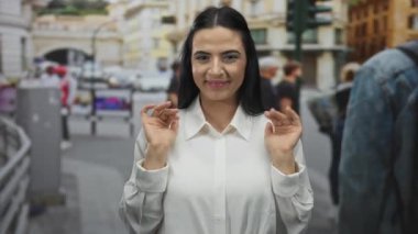 İspanyol kadın, insanlarla dolu bir sokakta dikilirken ve arka planda bulanık bir mimariyle ince bir hareketle reddedildiğini ifade ediyor..