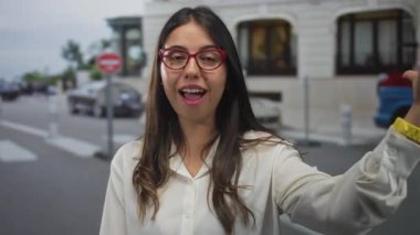 Genç İspanyol kadın binanın dışındaki hareketli bir caddeye öpüşme jesti yolluyor; şakacı bir flört..