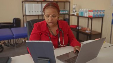 Kadın doktor steteskop tiplerini laptopta yumuşak ışık altında düzenli tıbbi ofis masasına koyuyor. Konsantrasyon.