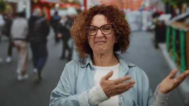 Woman standing confidently on a bustling city street surrounded by blurred pedestrians capturing a vibrant urban outdoor atmosphere in a sunny hispanic setting with dynamic energy.