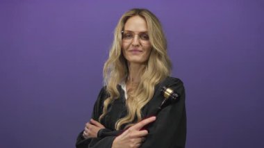 Üniformalı kadın yargıç, mor arka plan önünde tokmağı tutuyor, özgüven ve otorite yayıyor, dengeli bir ifadeyle, adalet ve hukuk kavramını iletiyor..