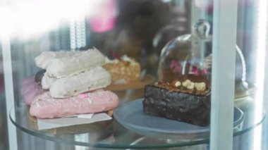 Kafeteryadaki cam bir kutuda sunulan tatlılar farklı malzemeli kekler içeriyor, canlı ve iştah açıcı bir manzara yaratıyor..