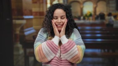 Kilisede canlı bir süveterle gülümseyen bir kadın canlı etkileşim ve kültürel ifade içeren etkinlik sırasında neşe ve sıcaklığı yansıtan renkli bir ortamda..