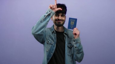 Elinde mor arka planda seyahat belgesi gösteren kot ceketli İsrail pasaportu tutan bir adam..
