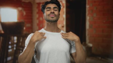 Genç İspanyol adam göğsüne kadar iniyor ve elleri bitmemiş inşaat işinde, kendine güveni tam..