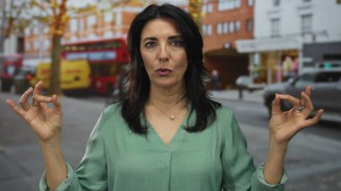 İspanyalı kadın, şehir otobüsü durağında göğsüne dua hareketi yaparak avuçlarını birbirine bastırarak avuçlarını kapatıyor..