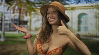 Bikini giyen kadın binanın önünde el pençe divan duruyor. Eğlenceli bir davet..