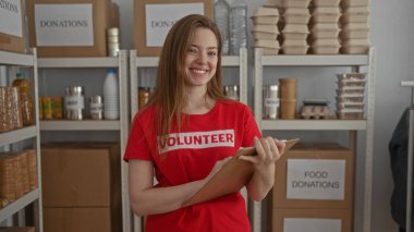 Gönüllü, binadaki bağışları sıralarken panoyu kontrol eder; merhamet toplum destek servisi.
