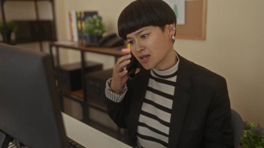 Modern ofiste telefonla konuşan bir kadın iş ortamında hayal kırıklığı ve kararlılığını ifade ediyor..