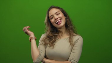 Latin kökenli genç bir kadın kol saati görünürde ve el yapımı stüdyo ile dillerini uzatıyor..