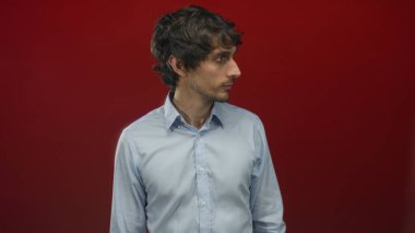 Kırmızı stüdyo duvarına karşı ağzı açık bir adam jest, portre tarzı baş yana dönük; şaşkınlık.