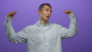 Mor izole duvarın önünde el kol hareketi yapan bir adam iletişim ve duygularını ifade ediyor düşünceli bir ifadeyle günlük giysiler giyiyor..
