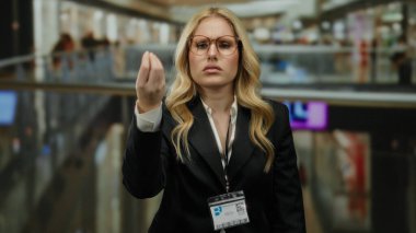 Gözlüklü genç bir kadın alışveriş merkezinde kimlik kartı takarak hayal kırıklığını ifade ediyor..