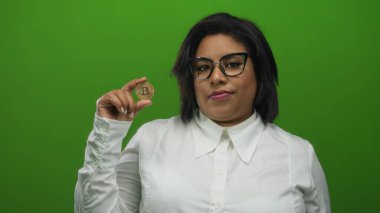 Bitcoin 'i canlı yeşil zemine karşı kendinden emin ifadeyle tutan kadın, kripto para birimi eğilimi ve dijital finans alanında kadın yetkilendirmesini vurguluyor.