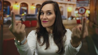 Gece vakti sokakta dolaşan kadın, hareketleriyle duygu ve meydan okumaları somutlaştırırken saat ve beyaz gömlek giyiyordu. Şehir ışıklarıyla zıtlaşmıştı ve geçmişi bulanıktı..