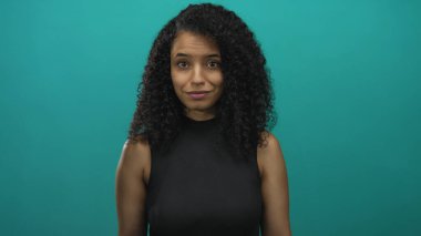 Avuç içleri açık genç İspanyol kadın, sıcak bir gülümseme ile semer duvara karşı stüdyoya çağırıyor; dostça bir davet.