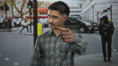 Genç bir adam kentin kalabalık caddesinde, hareketli ve dinamik bir açık hava sahnesini yakalar ve güvenli bir şekilde gülümser..