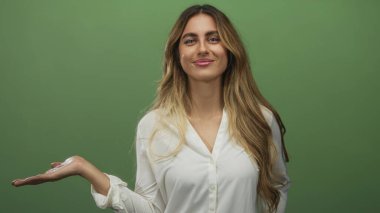 Genç sarışın kadın sol elini kaldırıyor ve yeşil bir stüdyoda işaret işareti yapıyor. Onaylama pozitifliği.