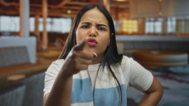 Lokantadaki çalışanları işaret eden bir kadın. Bu arada Latin asıllı genç müşteri içeride kızgın bir bakışla kahveyi tutuyor..