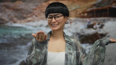 Sahilde uzanmış avuçlarıyla gülümseyen bir kadın, güneşli bir plaj günü, arka planda okyanus, rahat tatil havası sergiliyor..