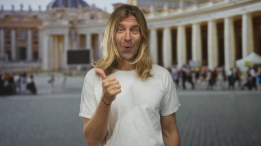 Sarışın adam binayı süslemek için sağı işaret ediyor. Arkasında kalabalık var. Meraklı bir keşif..