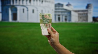 Arka planda Pisa 'nın sembolik mimarisi olan Hong Kong banknotları, küresel yatırımı ve açık hava döviz kurunu simgeliyor..