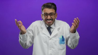 Beyaz önlüklü İspanyol bilim adamı, stüdyoda mor arkaplan ile omuz silkiyor; belirsizlik.