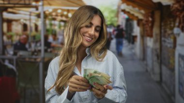 Meşgul sokak kafesinde banknotları çıplak elle sayan kadın parmaklarının arasından banknotlar atıyor; zenginlik mutluluğu.