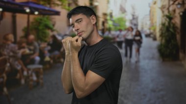 Siyah gömlekli, yumruklarını sıkmış bir adam kaldırılmış bir kaldırım taşı sokakta; kararlılık dayanıklılığı.