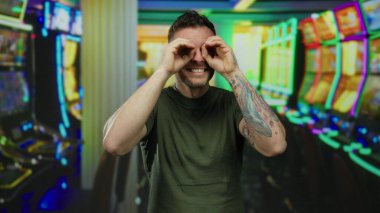Kumarhanede dövmesi olan genç bir adam. Parlak kumar makineleri arasında neşe saçan kapalı mekanda..