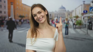 Aziz Peter Meydanı 'ndaki bir binaya gülümseyen ve parmağını yukarı gösteren bir kadın. Huzur..