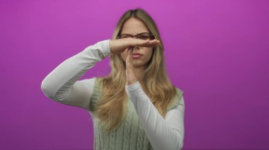 Gözlüklü ve kablo örgü yelekli bir kadın stüdyoda el ele tutuşuyor..