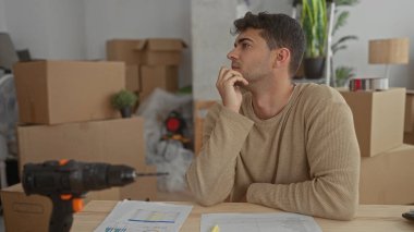 Genç İspanyol kutucuklar eşyalar yerleştirirken adam evde el ele tutuşup dinleniyor..