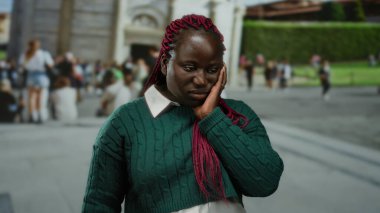 Pembe örgülü kadın İtalya 'daki sidik kulesinin önünde poz veriyor, turistlerle ve arka planda tarihi mimariyle huzurlu bir anı yakalıyor..