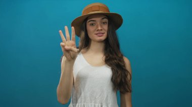 Genç İspanyol kadın stüdyo seansında ardışık parmak sayısıyla el ele tutuşuyor. Eğitimden alınan neşeyi sayıyor..