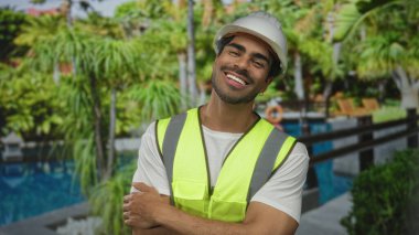 Binada kolları bilardo sahasında kesişen koyu şapkalı ve neon yelek giyen genç İspanyol bir adam, güven gururu iyimserliği hırsı.