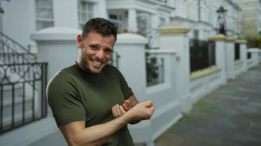 Şehir sokağında genç bir adam görünmez bir ip çekiyor ve kolunda şehir dışında görülebilen bir dövme var.